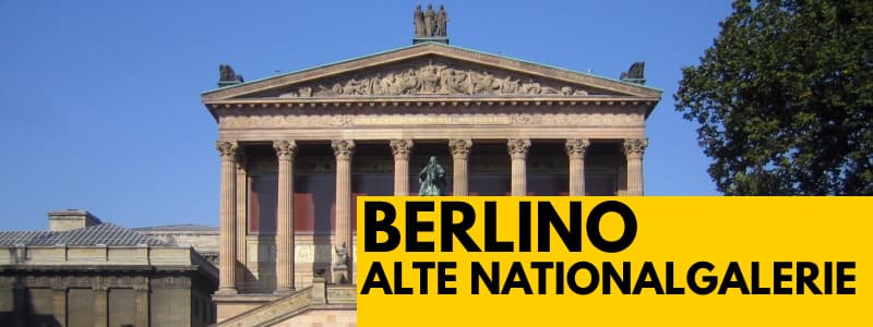 Fotografia dall'esterno dell'Alte Nationalgalerie di Berlino a forma di tempio romano con un albero sulla destra. In basso a destra rettangolo giallo con scritta nera Berlino Alte Nationalgalerie