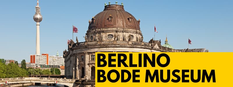 Fotografia dell'esterno del Bode Museum di Berlino in una giornata serena con rettangolo giallo in basso a destra con scritta nera Berlino Bode Museum