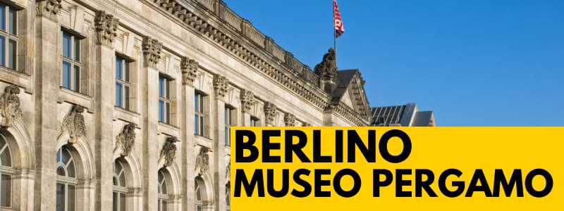 Fotografia dell'esterno del Museo di Pergamo di Berlino con cielo azzurro e rettangolo giallo in basso a destra con scritta nera "Berlino Museo Pergamo"